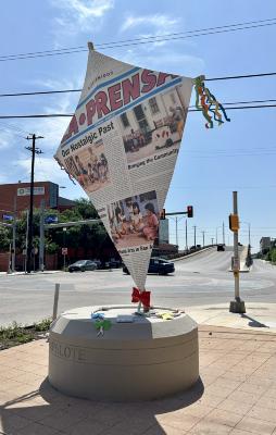 A series of two scuptures 1. El Papalote One sculpture in the shape of a kite that appears to be fashioned out of "La Prensa" newspaper. 2. El Trompo One sculpture in the shape of a toy top that is painted in bright colors with a metal cord that looks like rope wound around the body.