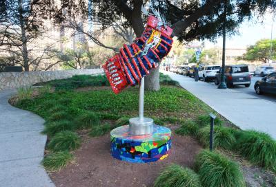 Mosaic sculpture of an outstretched accordion on a mosaic base.